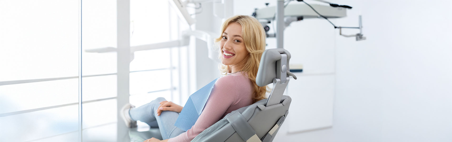 A woman sitting in a modern dental chair with her feet up.