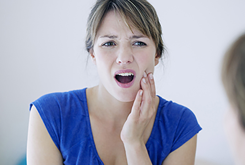 A woman with her mouth open, looking upwards, possibly experiencing discomfort or pain.