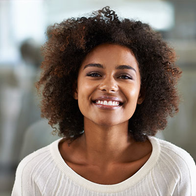 Woman with curly hair smiling at camera.