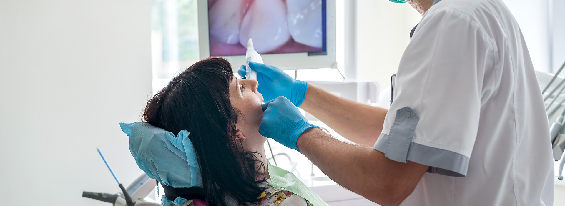 A dental professional performing a procedure on a patient s mouth.